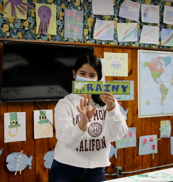 Jazmin at CYO holding up a sign that reads rainy