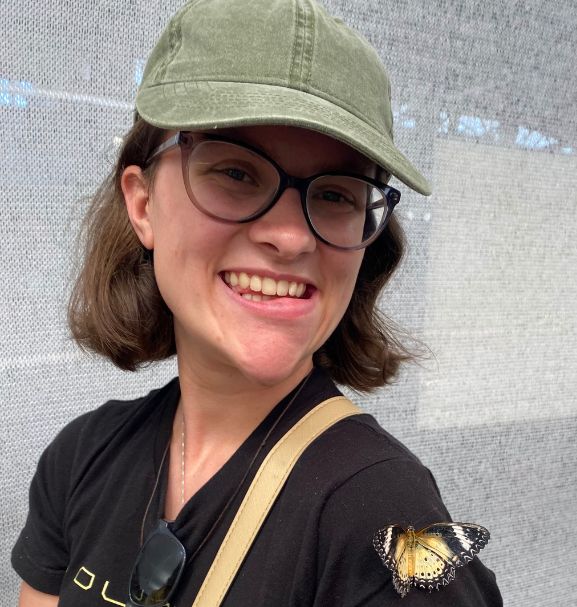 Photo of Savannah Buckmaster for her first reflection. She is pictured with a butterfly on her shoulder.